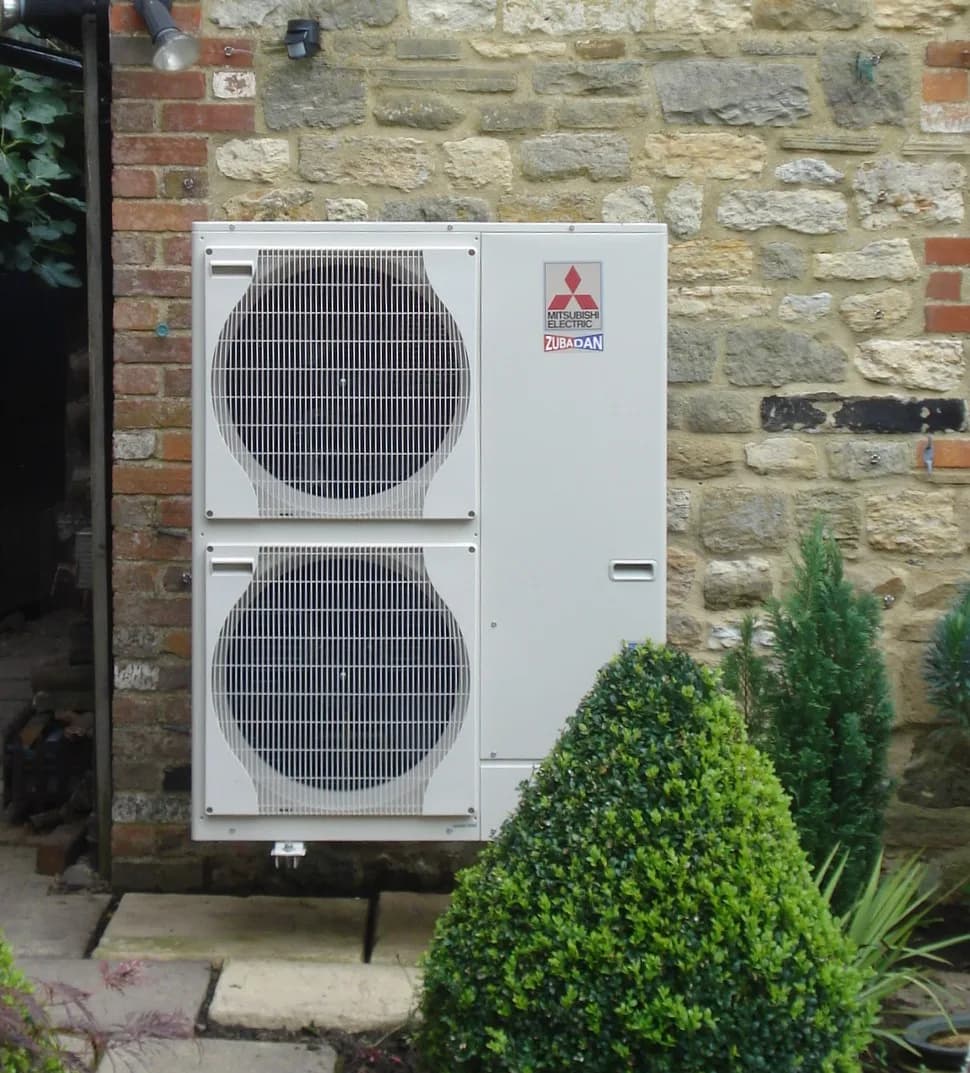 An air-source heat pump we installed against the stone wall of a cottage